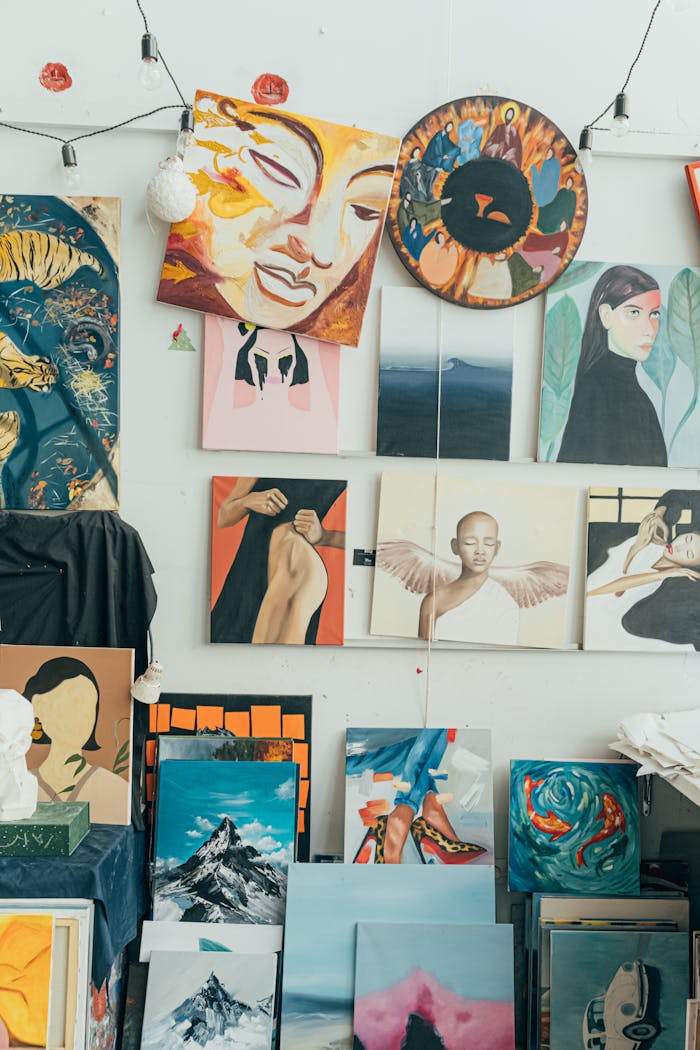 Explore a colorful array of diverse paintings displayed on a white wall in a creative art studio.